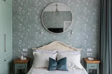 Большое круглое зеркало над изголовьем кровати в спальне