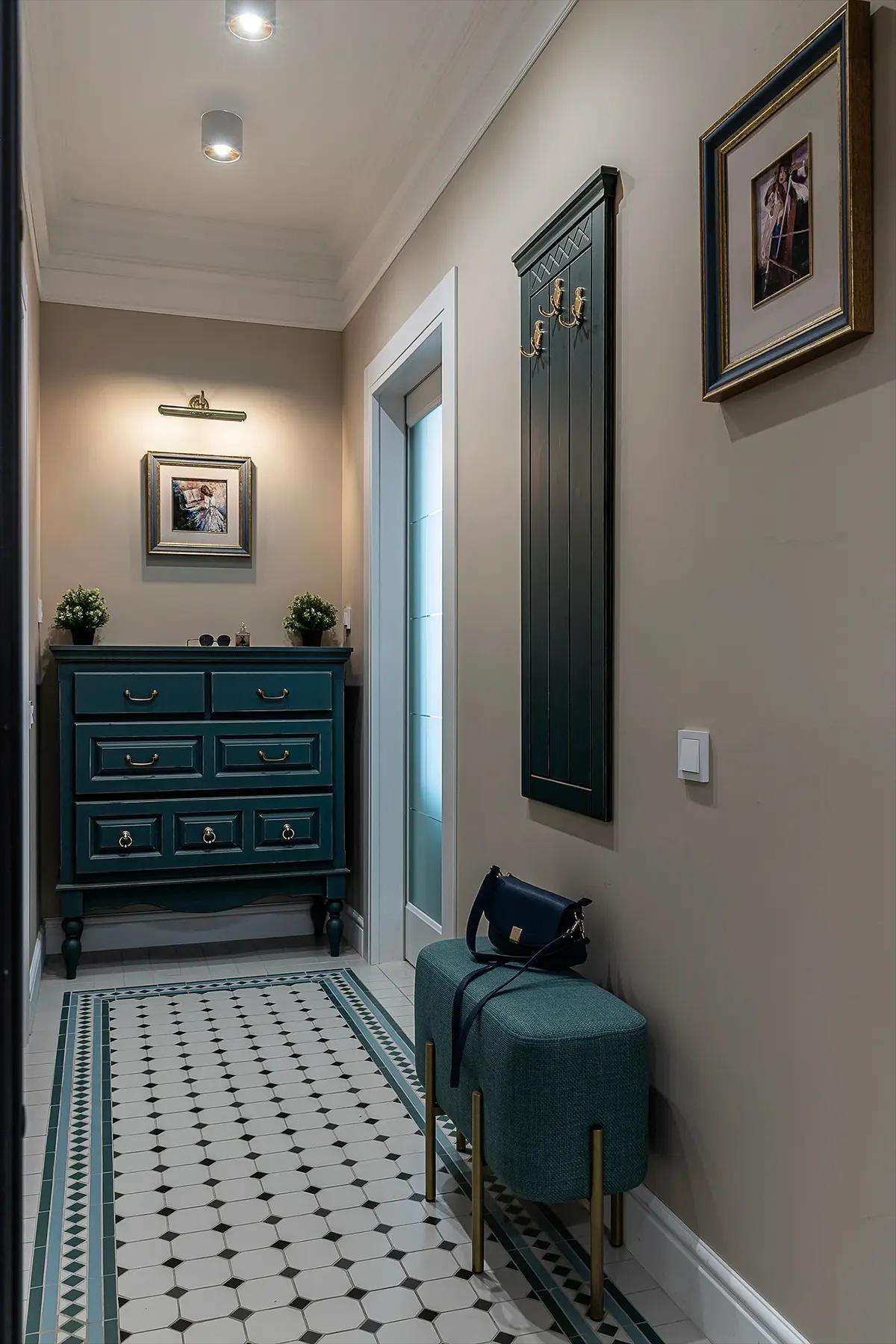 Массивный комод темно-зеленого цвета в узкой прихожей