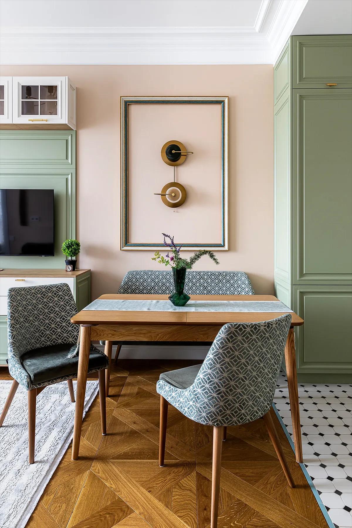 Обеденная зона с классической мебелью в кухне-гостиной с абстракцией на стене