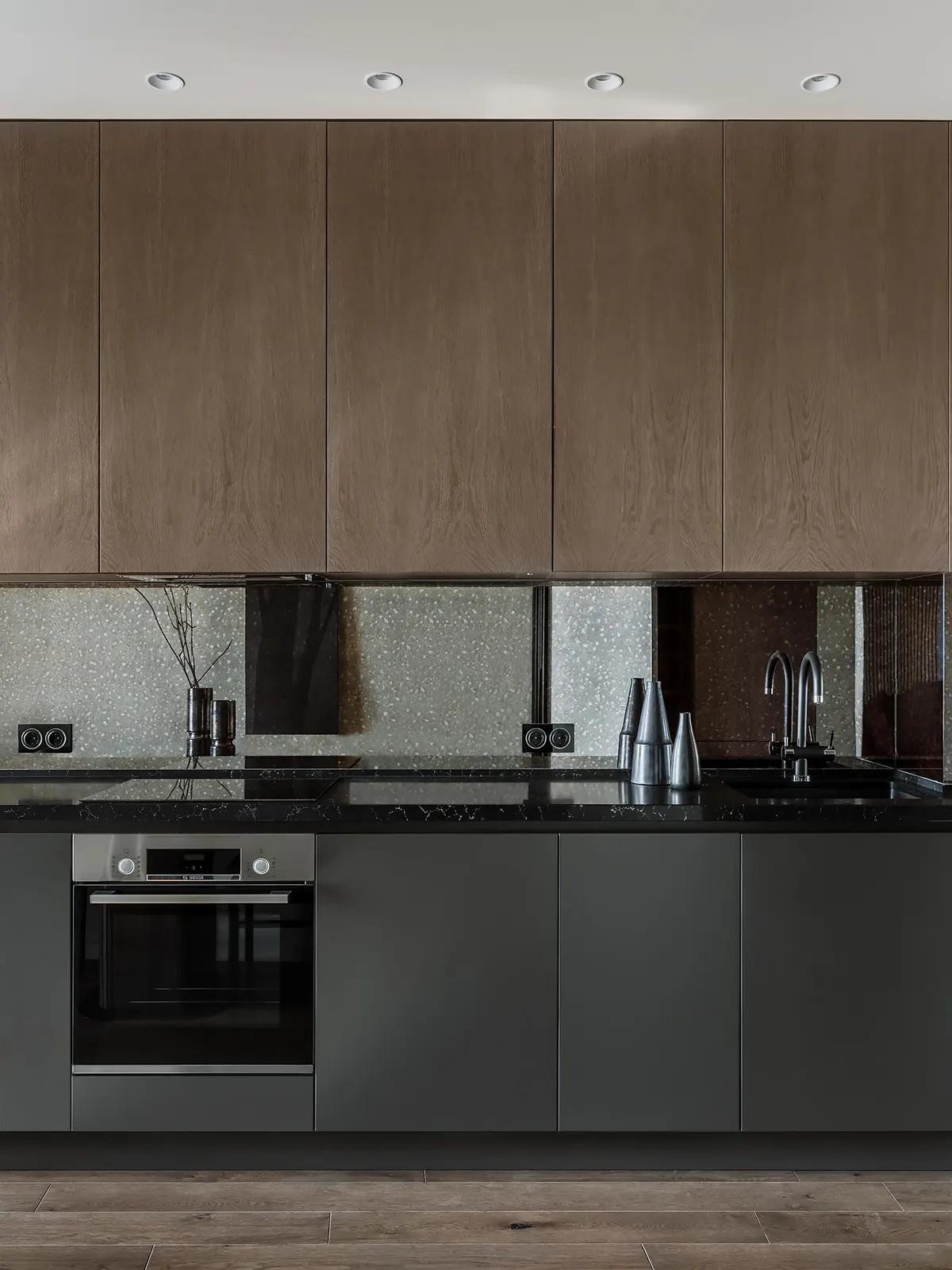 Современная кухня с деревянными верхними шкафами, серыми нижними шкафами и черной мраморной столешницей