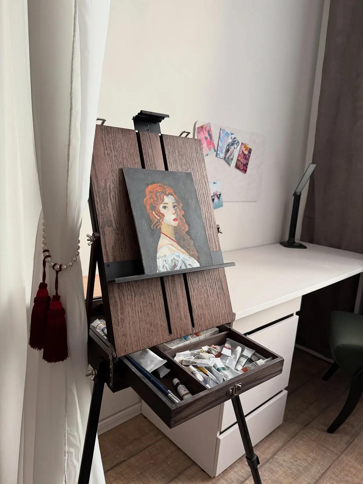 Мольберт с портретом рыжей женщины, красками