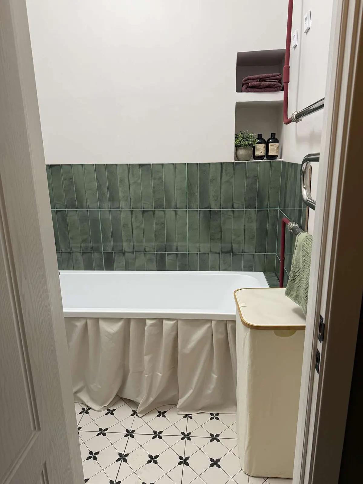 Ванная комната с зеленой плиткой с нишей в стене для принадлежностей