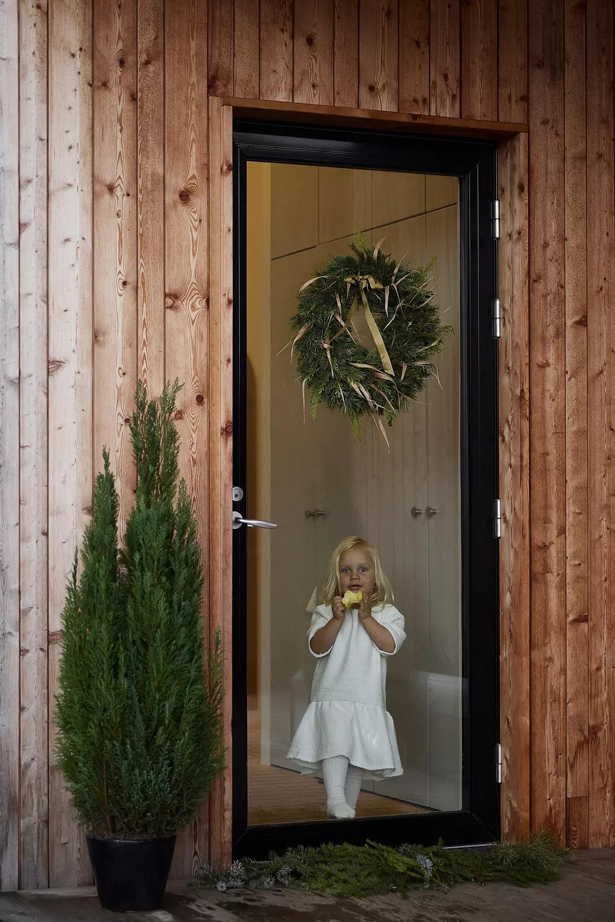 Маленькая девочка в белом платье за стеклянной дверью