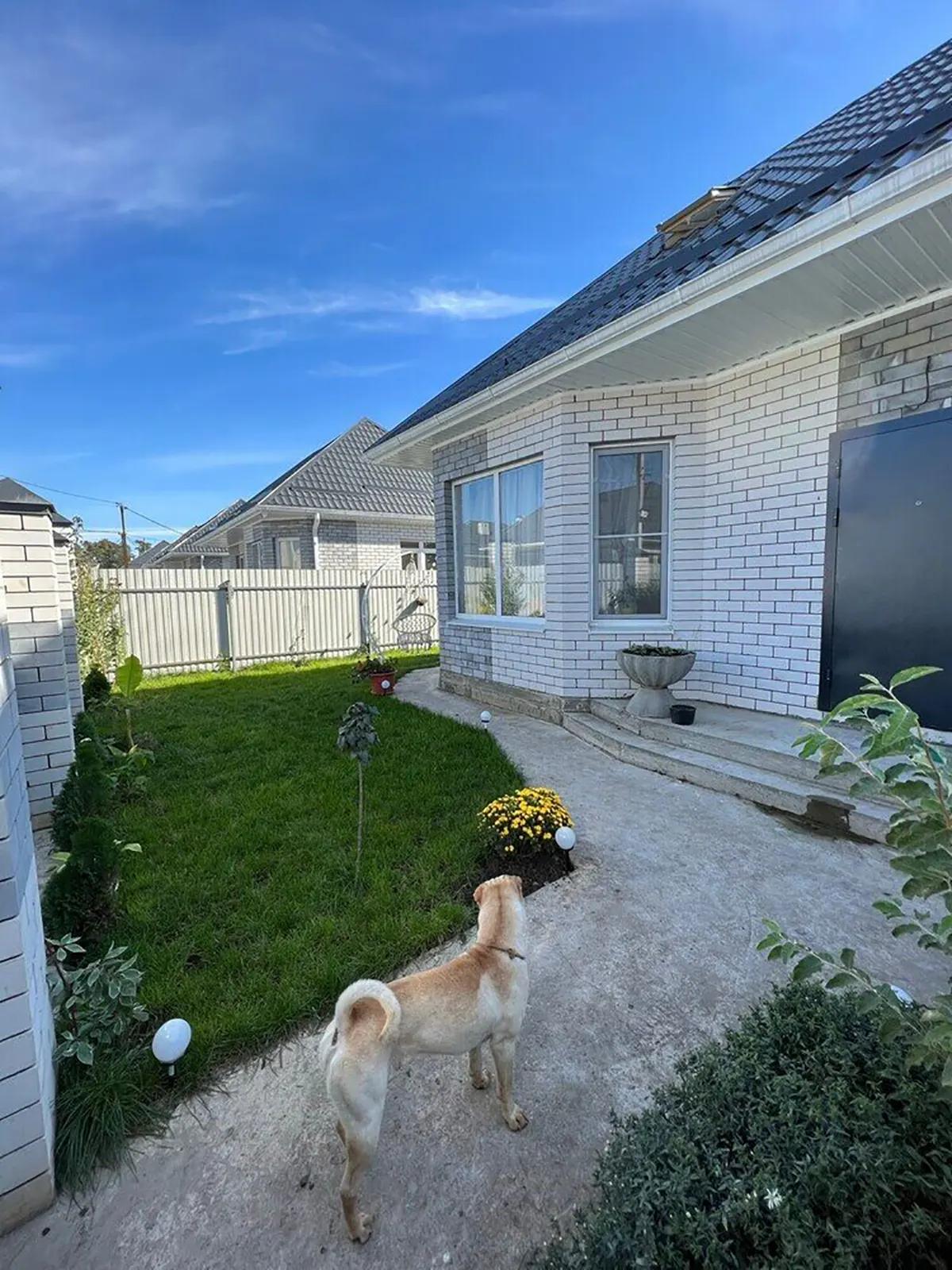 Внешний вид белого кирпичного дома с черной крышей