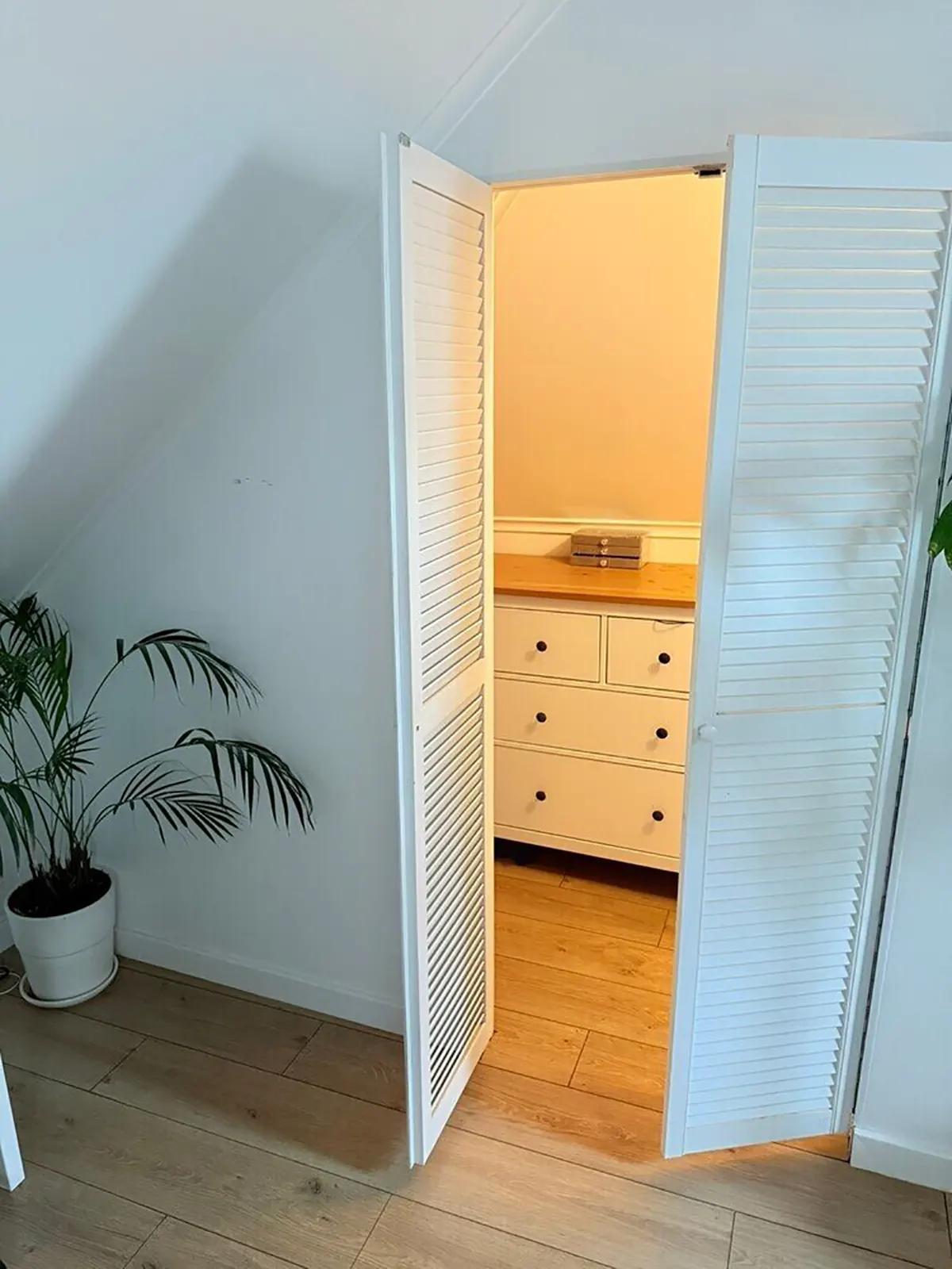 Комод в гардеробной за жалюзийными дверцами