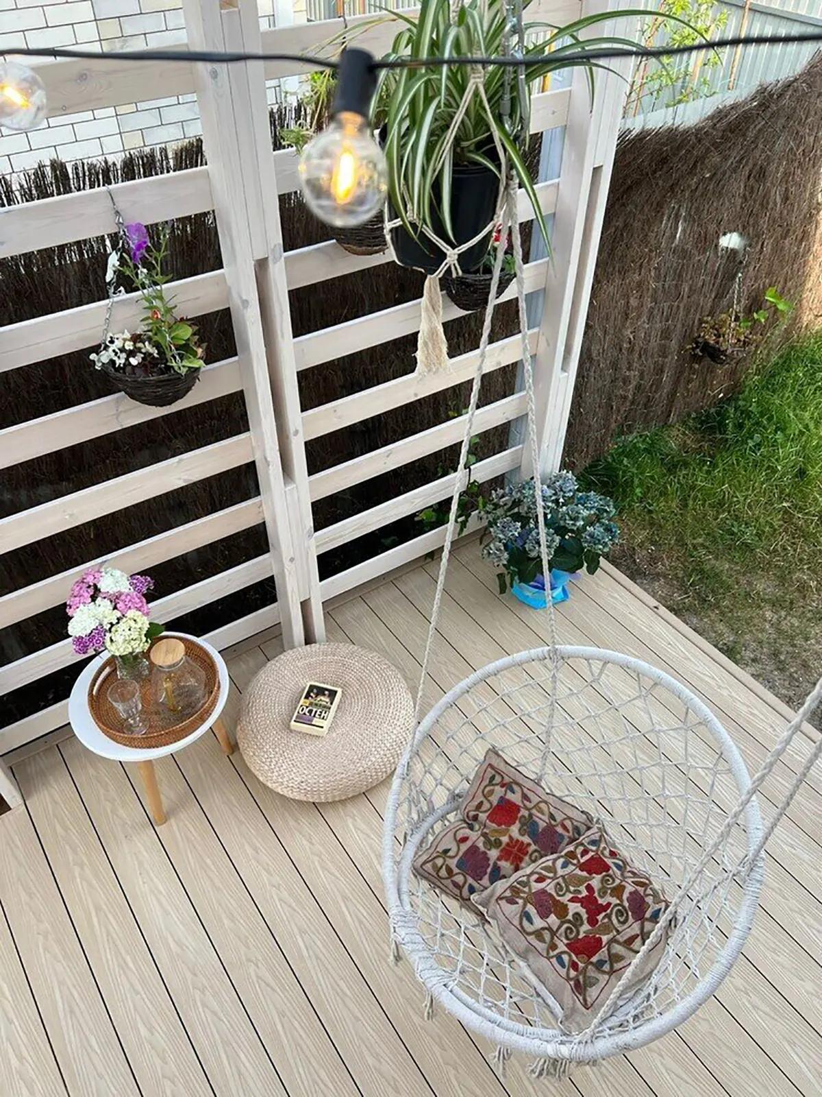 Вид сверху на террасу и качающееся кресло с подушками