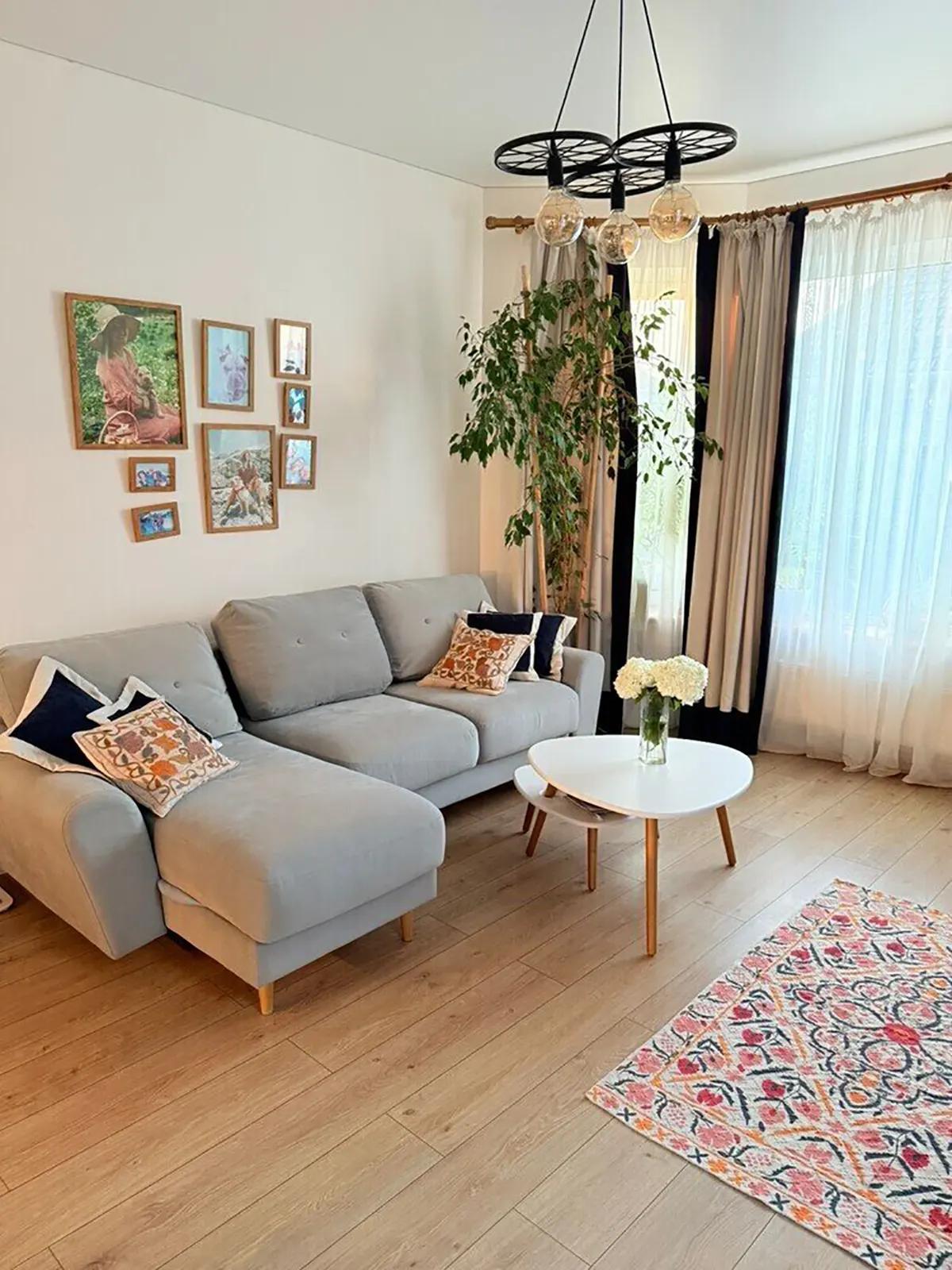 Серый угловой диван в гостиной. Черная люстра из велосипедных колес