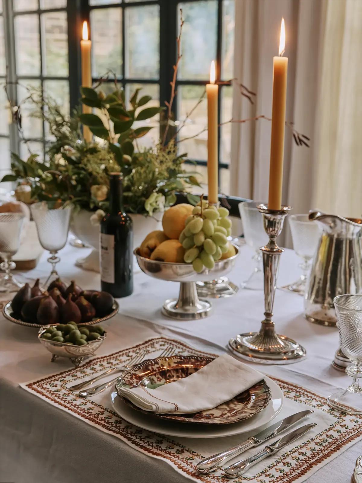Праздничный стол с зажжёнными свечами,вином, фруктами (инжир, оливки, виноград)