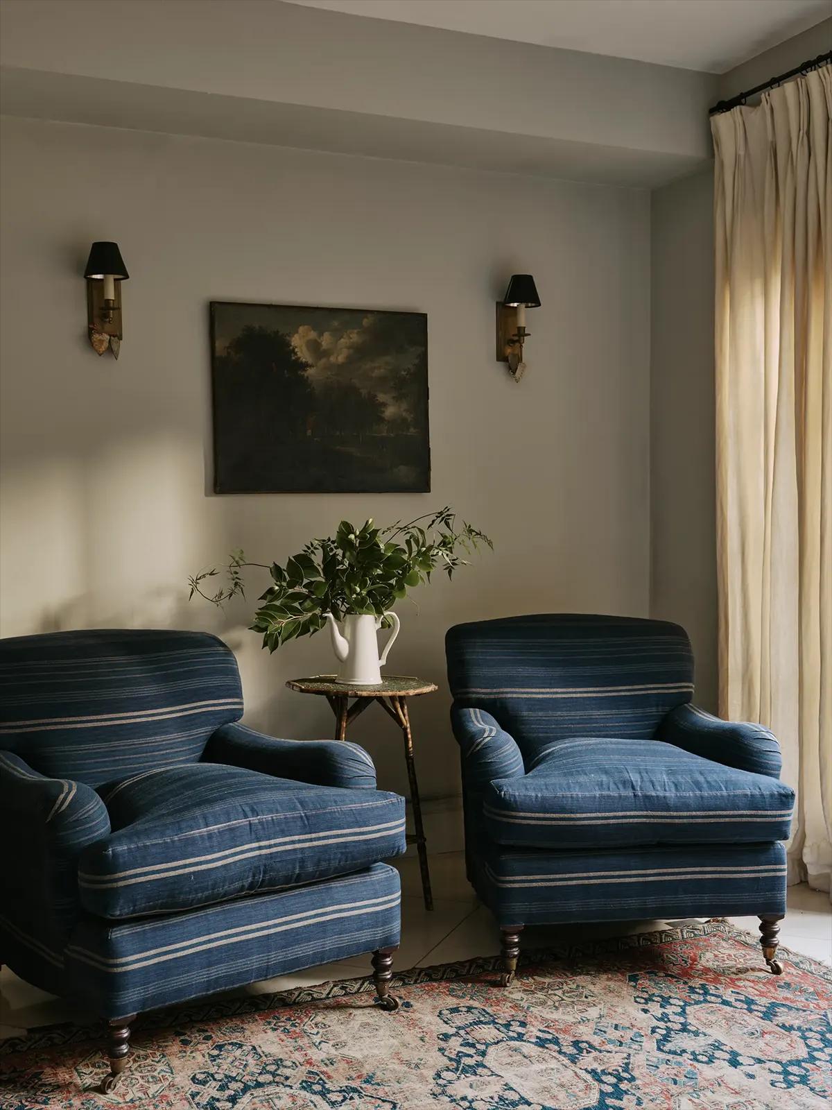 Уютный уголок с двумя синими полосатыми креслами, маленьким столиком с белым кувшином