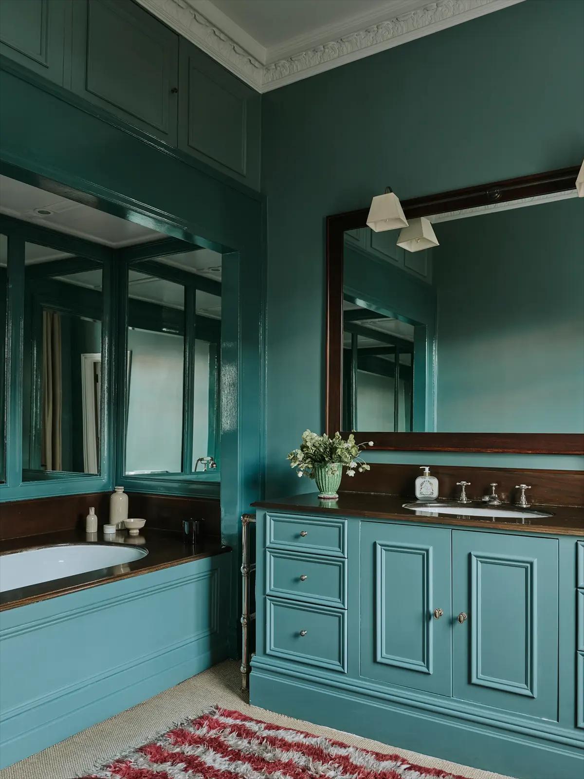 Ванная в бирюзовом цвете с большим зеркалом, умывальником и ванной