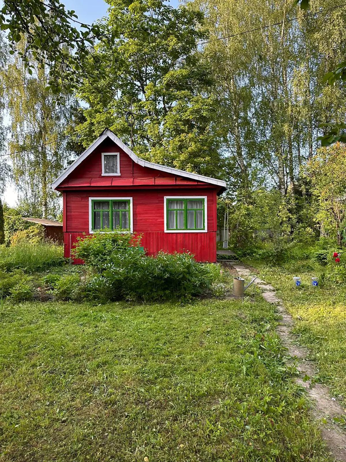Ярко-красный летний домик летом