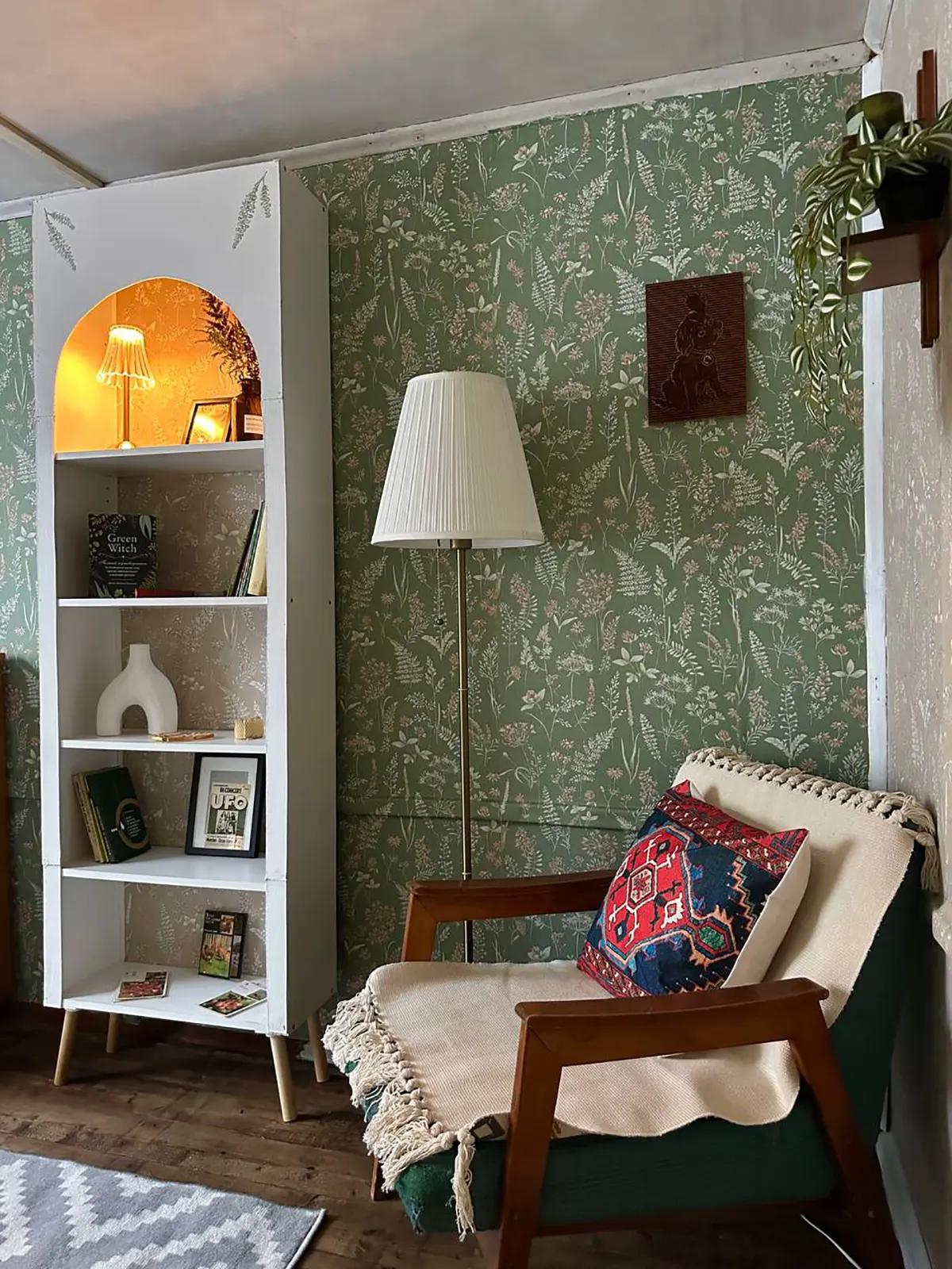 Зона отдыха в гостиной с ретро-креслом, напольной лампой и белый книжный шкаф с арочной нишей