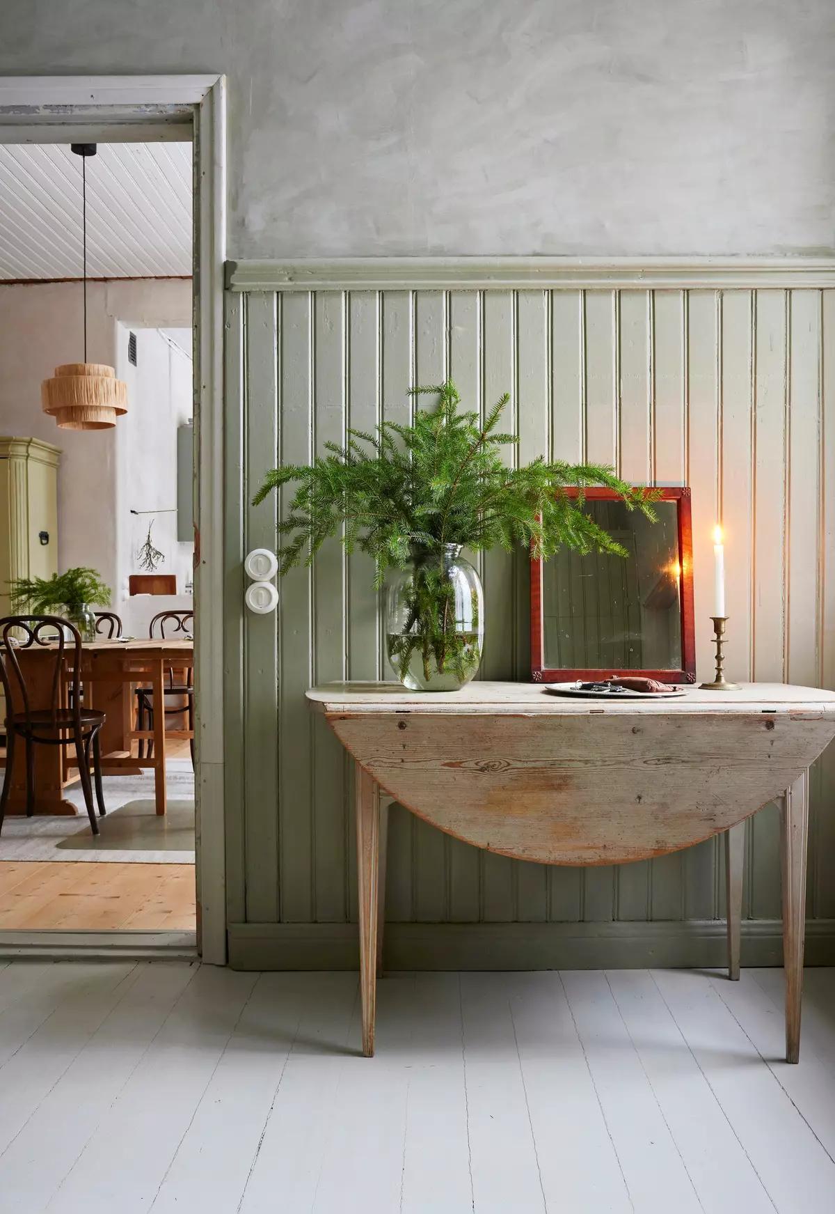 Консольный стол с еловыми ветками в вазе, зеркалом и свечой