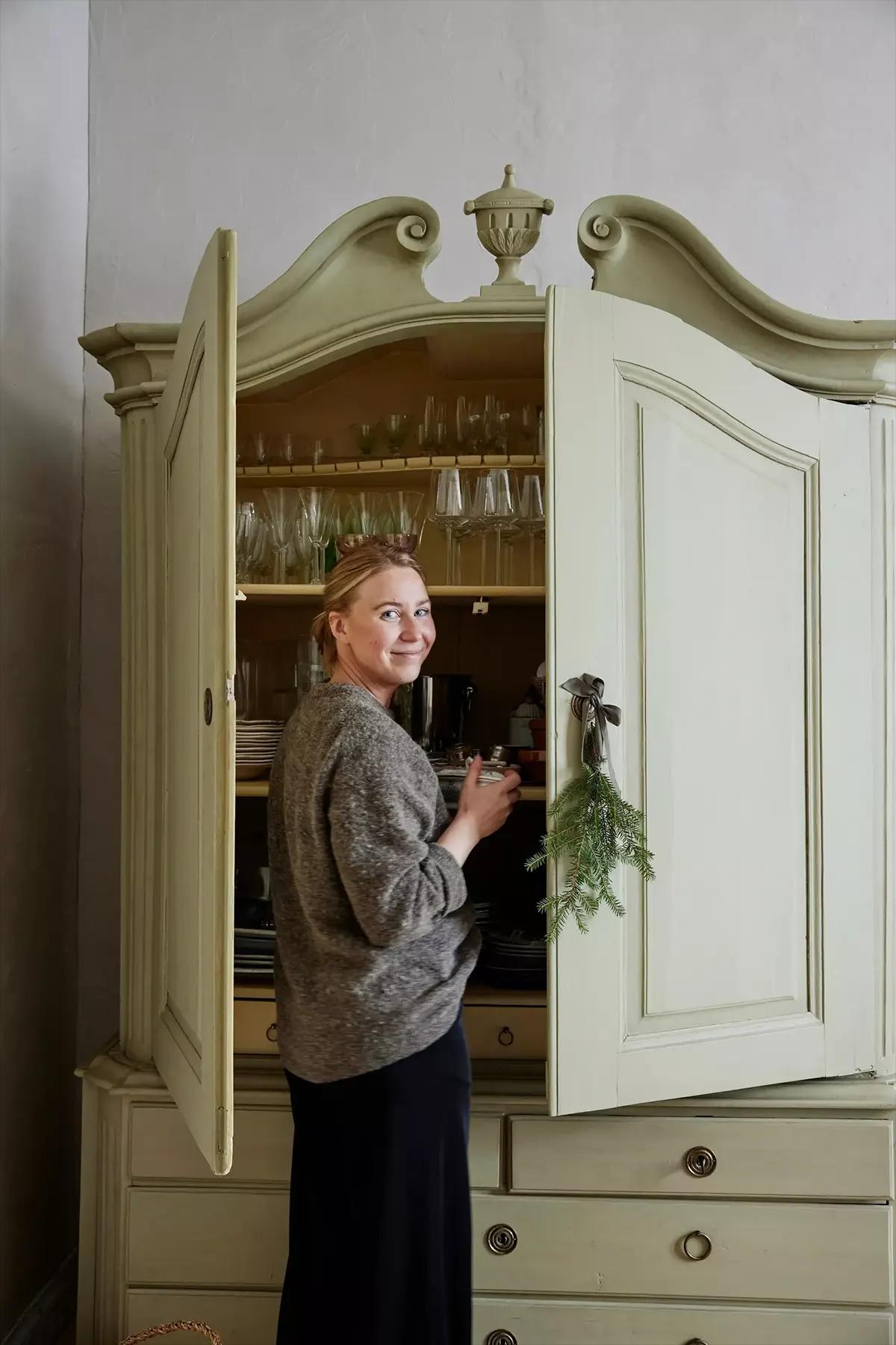 Девушка рядом с открытым светло-зеленым шкафом