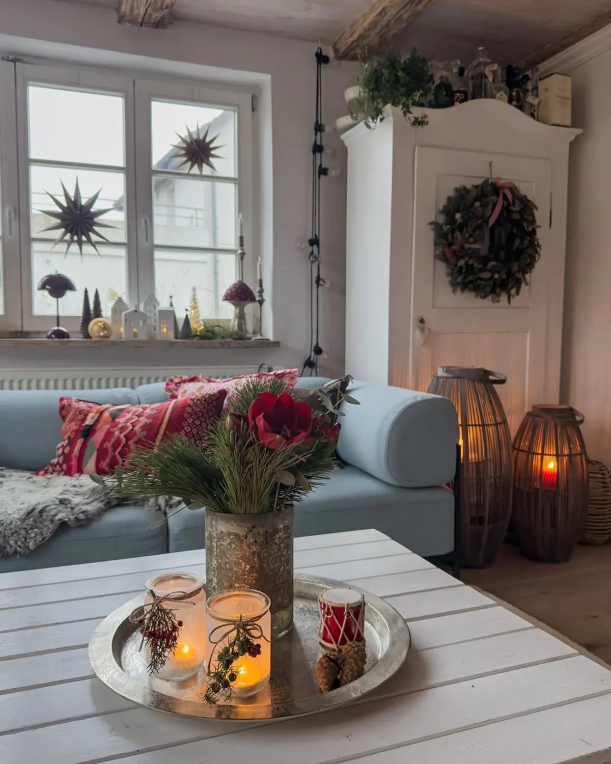 Серебряный поднос с горящими свечами и рождественской композицией