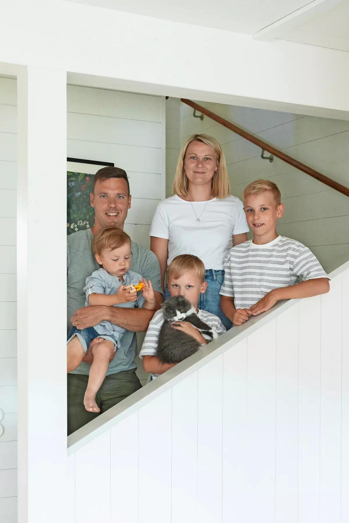 Молодая финская семья на пороге своего дома с тремя детьми и котом