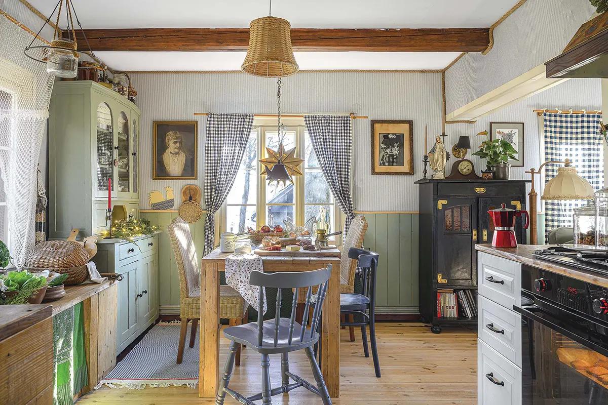 Кухня с деревянным столом, сервированным едой, зеленым буфетом и клетчатыми шторами