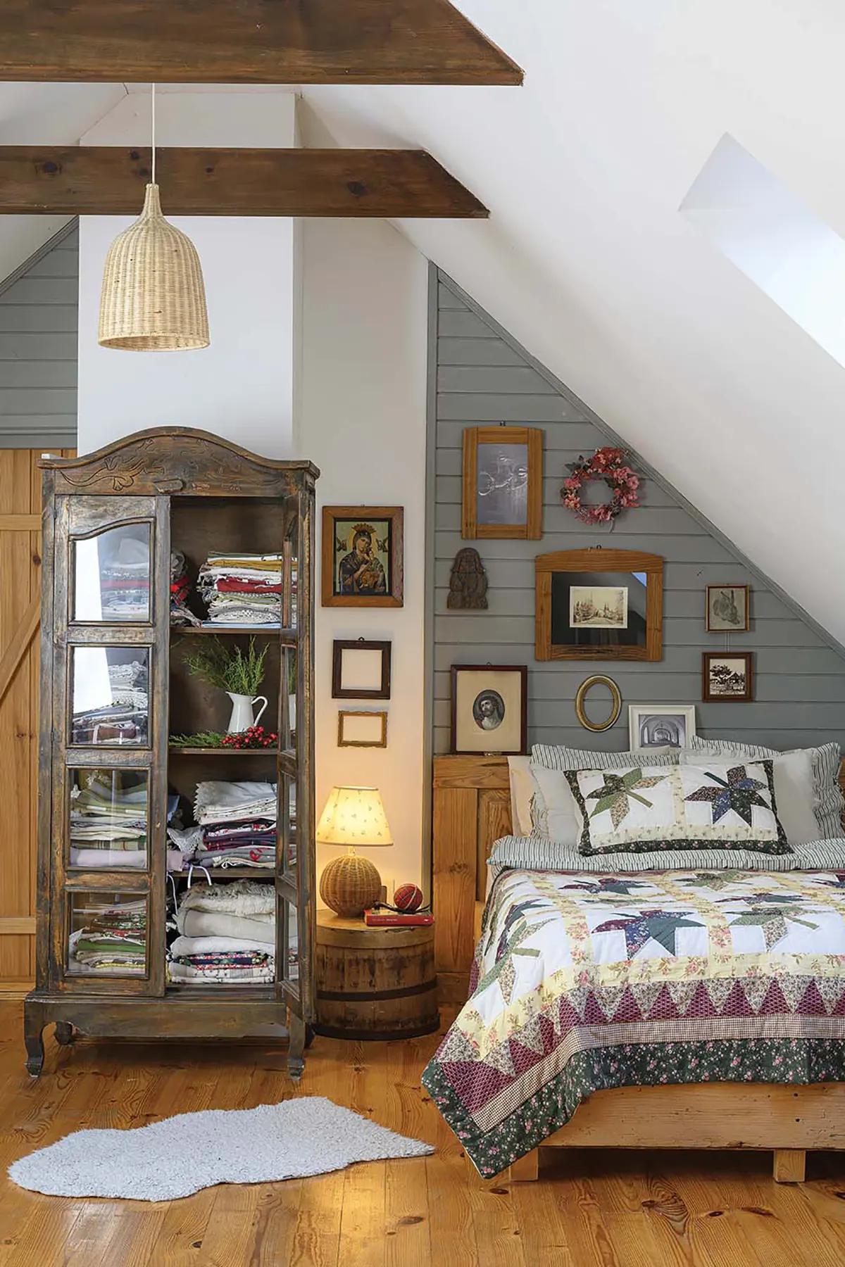 Спальня в деревенском стиле с лоскутным одеялом и деревянным шкафом-витриной