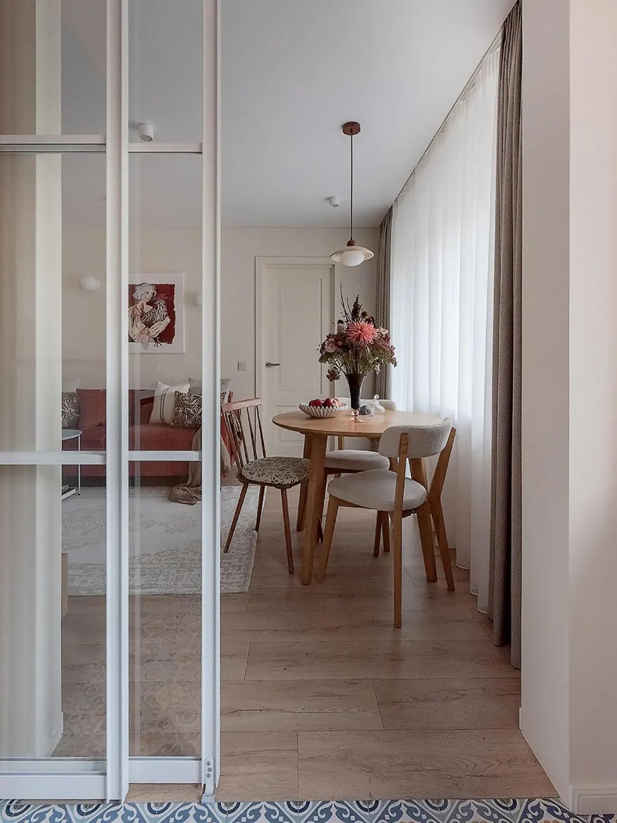 Вид через стеклянную дверь на гостиную с круглым столом