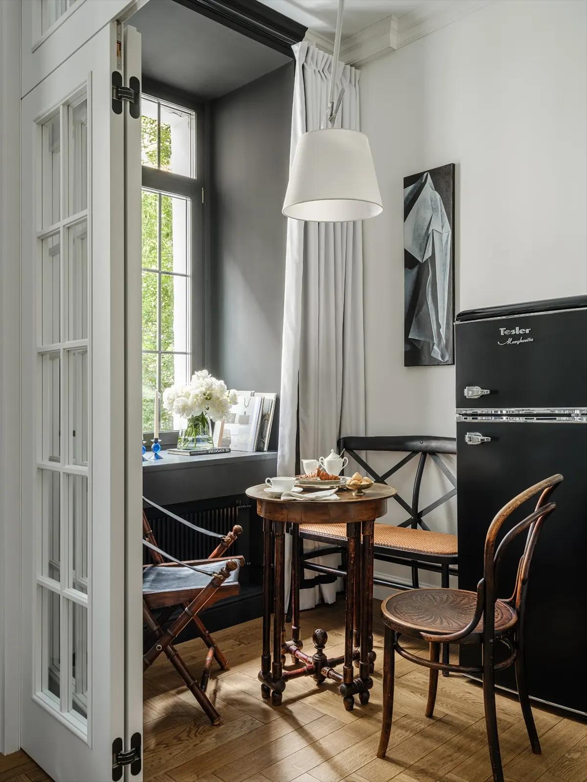 Вид на обеденную зону с черным холодильником