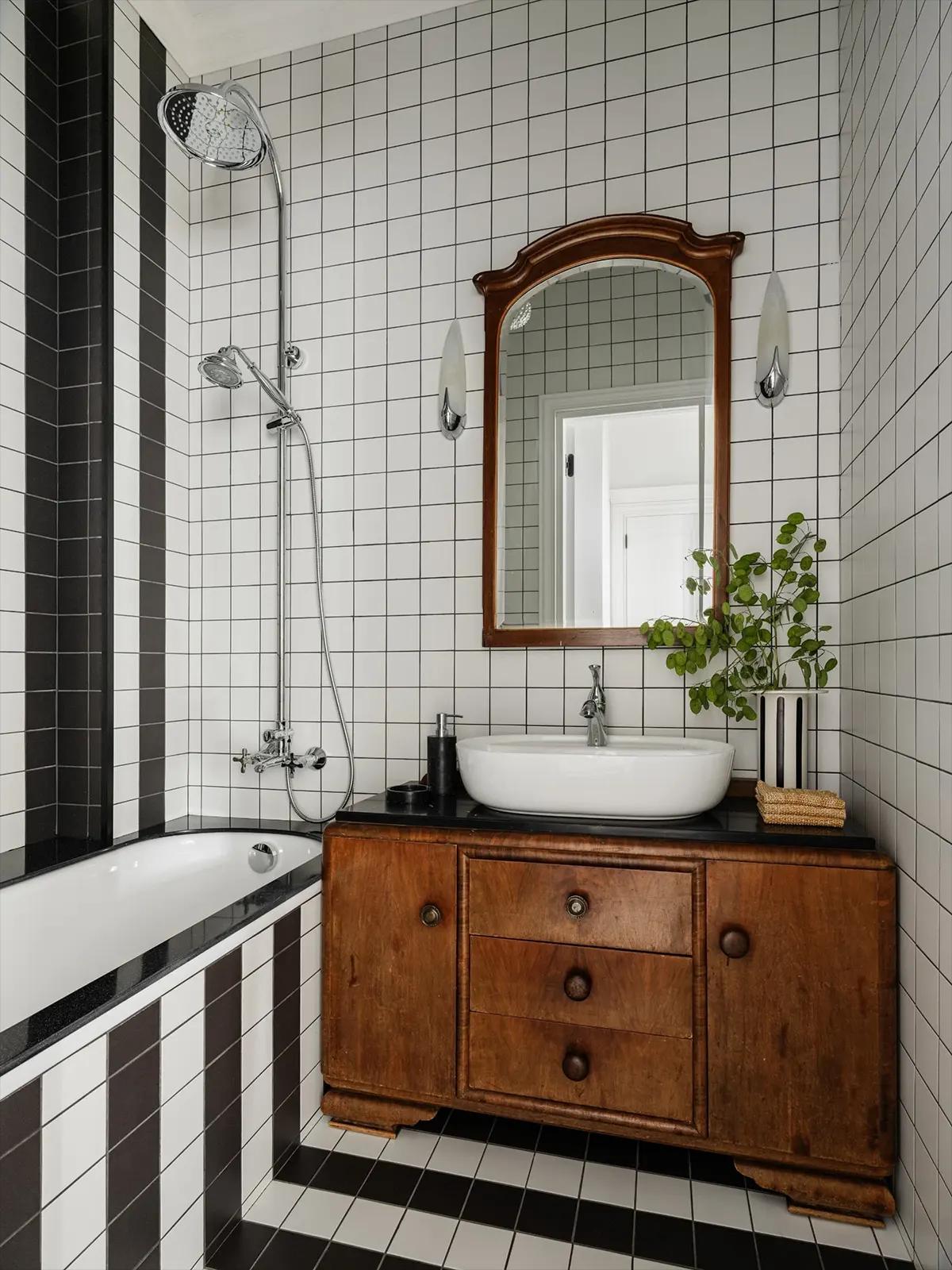 Угол ванной с раковиной, массивным деревянным комодом, зеркалом в деревянной раме