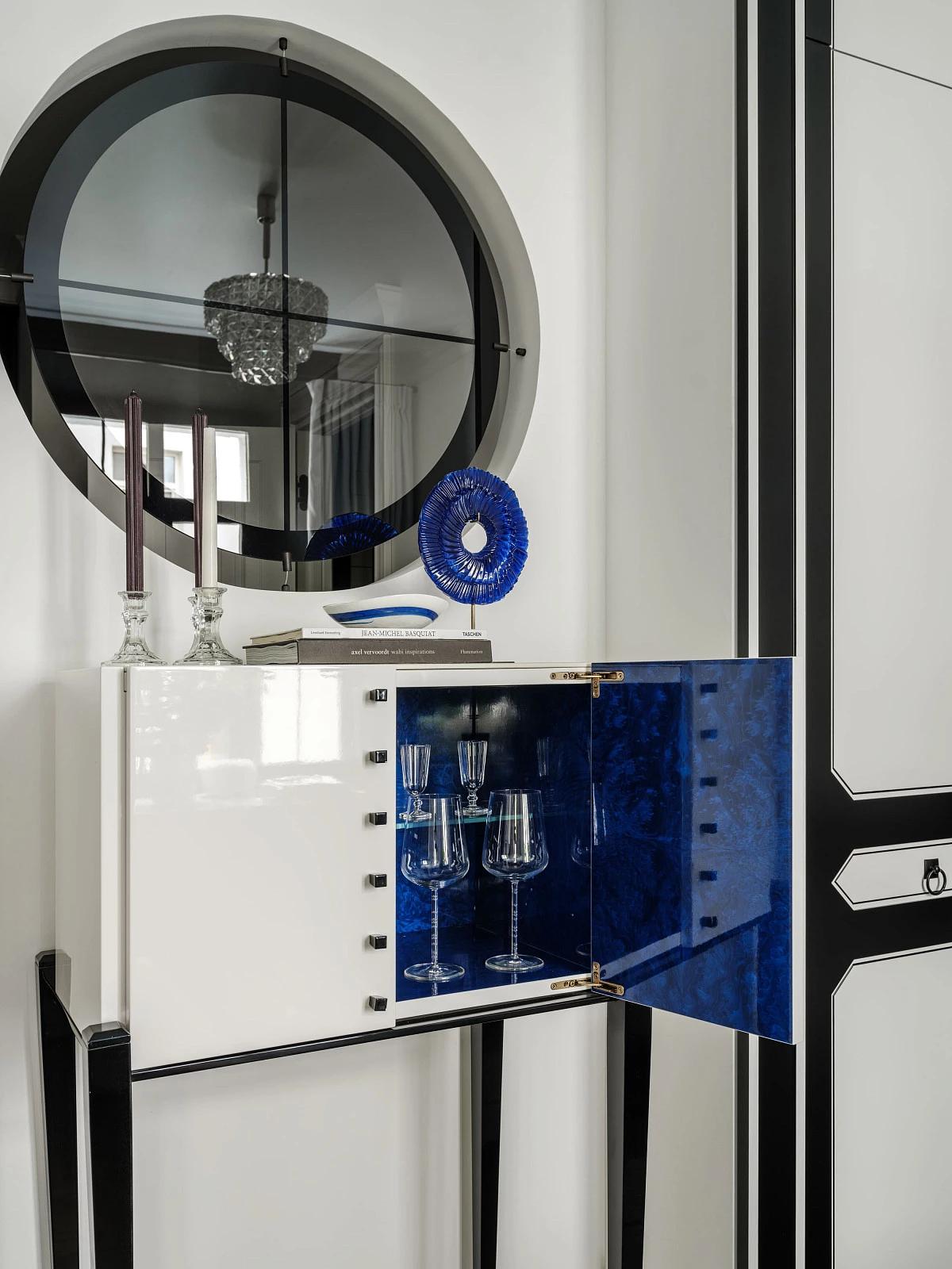 Открытый белый шкафчик с синим интерьером и бокалами внутри