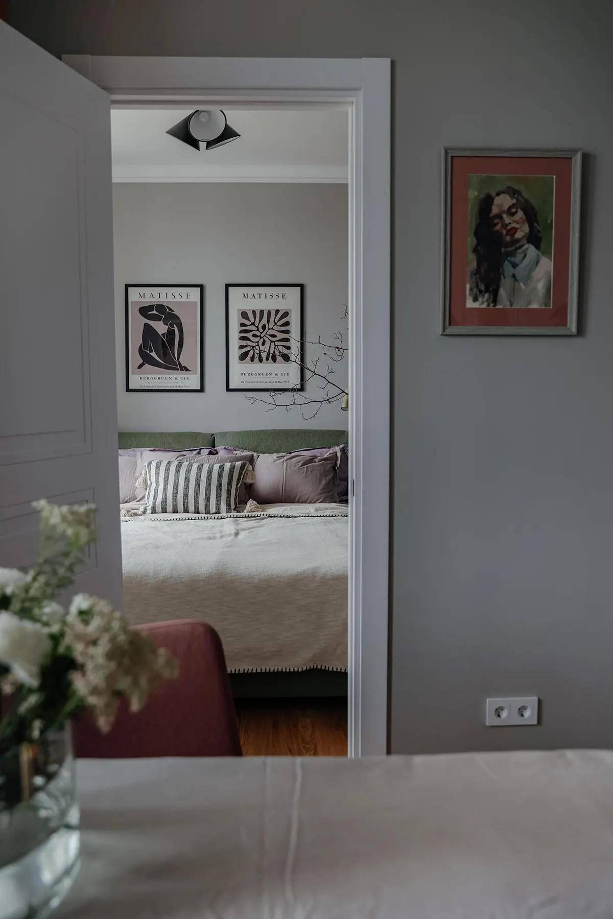 Вид через дверной проем на спальню с зеленой кроватью