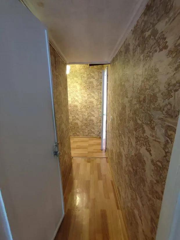 Коридор в брежневке с коричневыми обоями и ламинатом "под дерево"