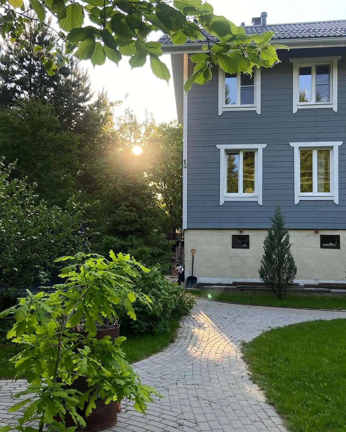 Серый дом с садовой дорожкой и растениями