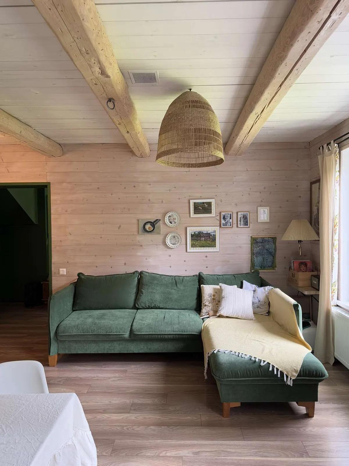 Зеленый угловой диван на деревянных ножках в гостиной