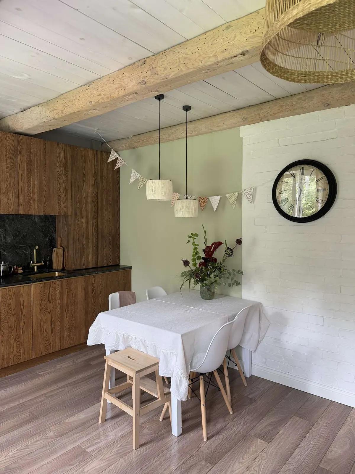 Обеденная зона на кухне с цветами и белой скатертью на столе