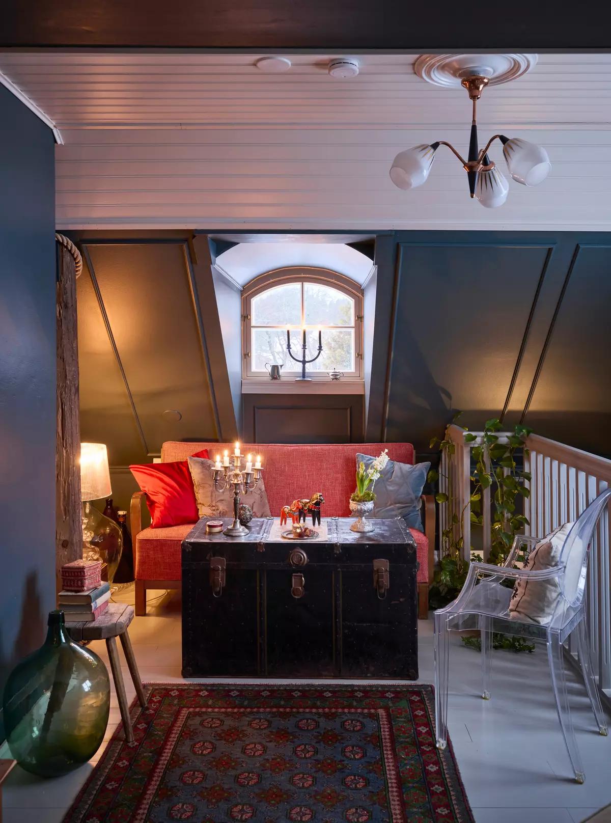 Диван и старинный черный сундук вместо стола на лестничной площадке второго этажа дома