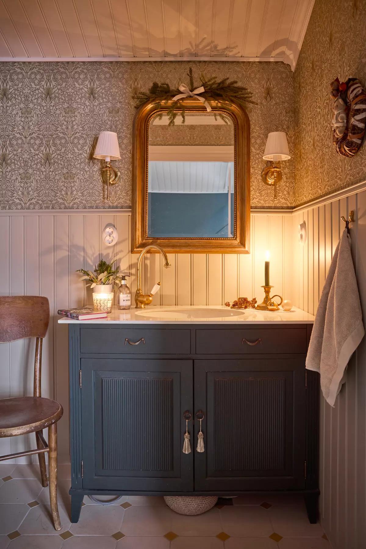 Раковина в ванной комнате с белой мраморной столешницей и темно-синей тумбой