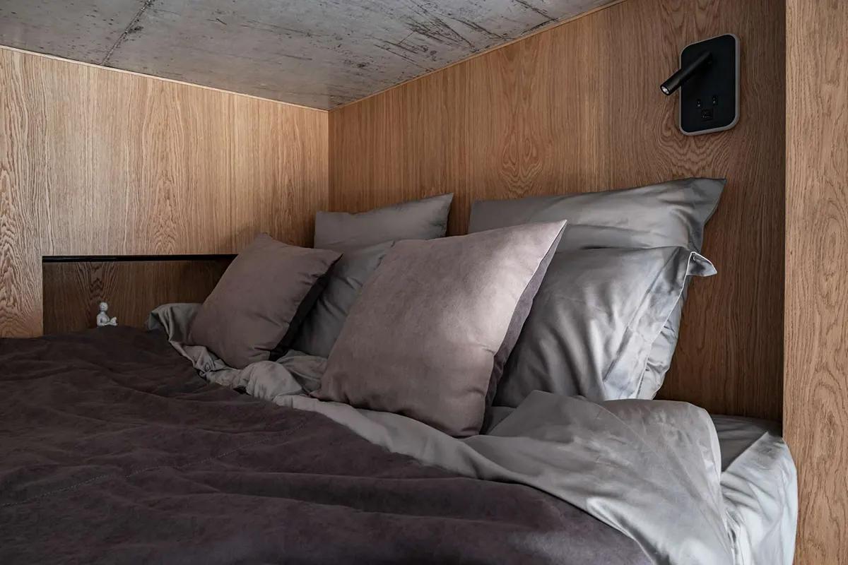 Спальня на антресоли в крошечной студии 19 кв.м с деревянными стенами и бетонным потолком