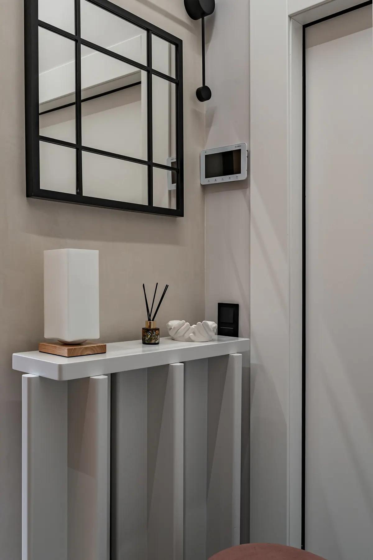 Зеркало в крупную черную сетку в прихожей студии 