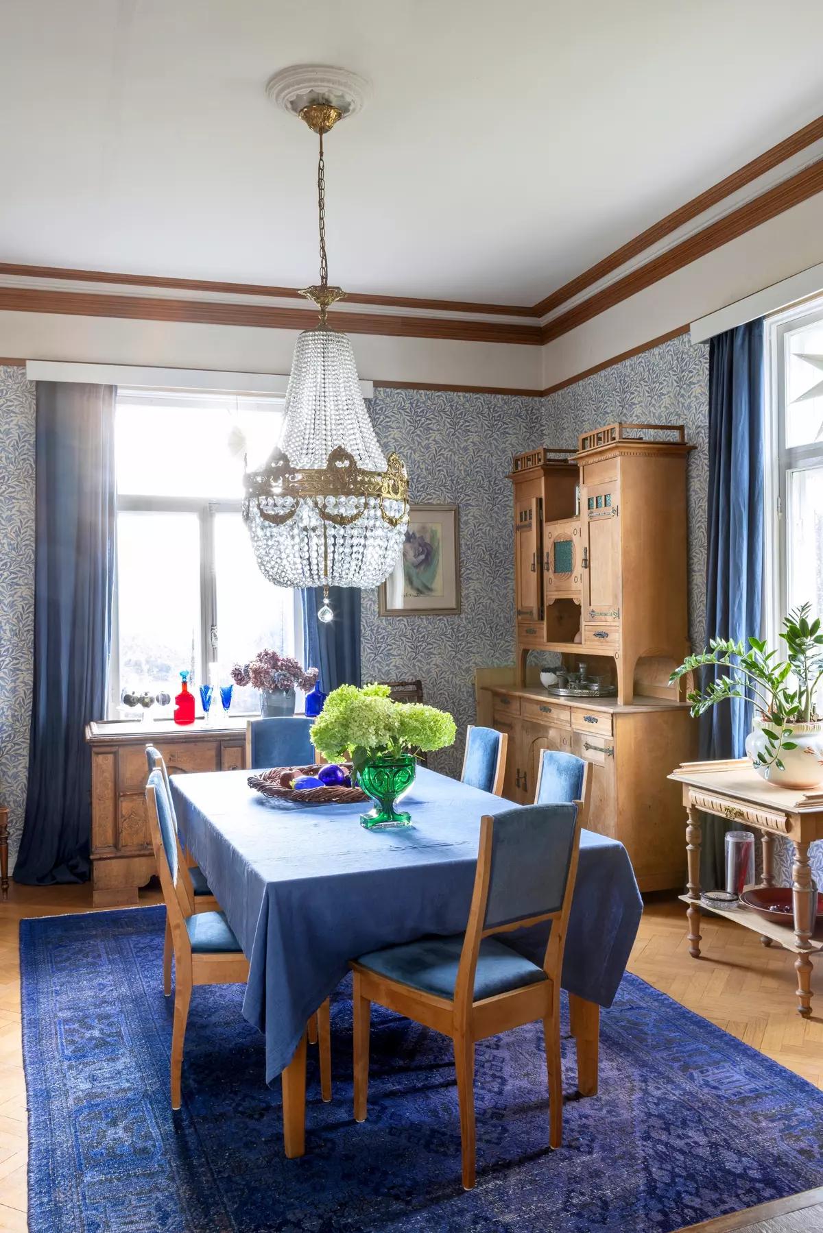 Обеденная зона с деревянными стульями, синей скатертью и ковром под столом