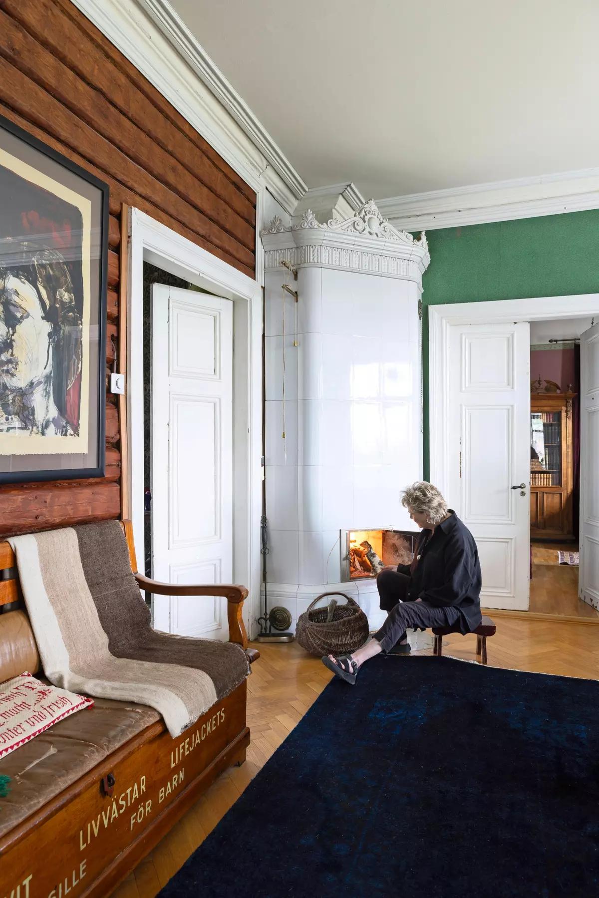 Уголок со старой печью в гостиной дома и деревянной скамейкой