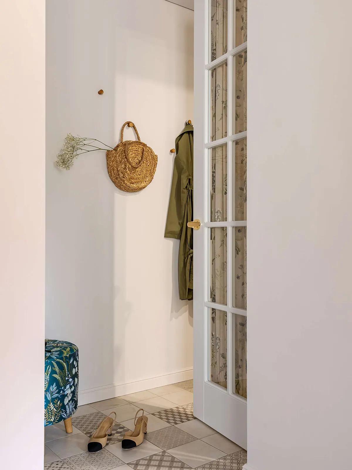 Соломенная корзина с сухоцветами на стене в светлой прихожей