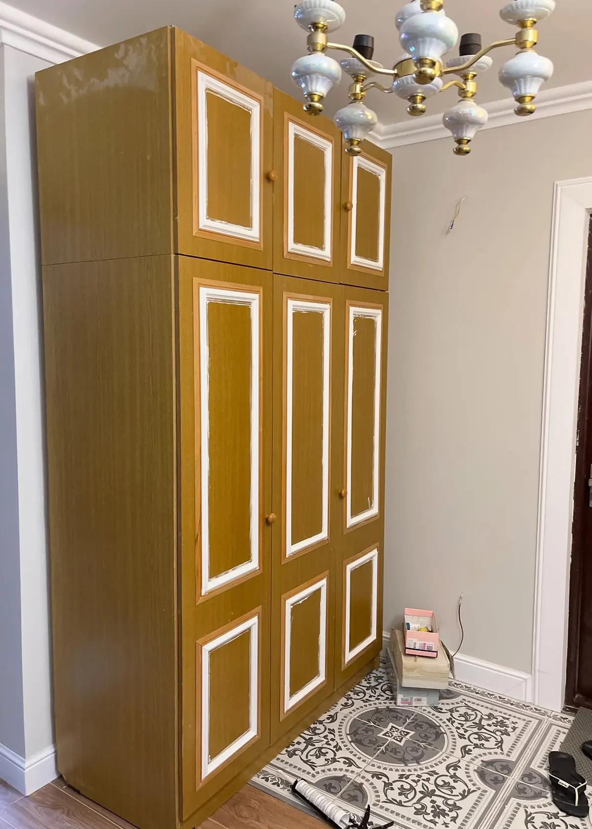 Старый советский шкаф в золотисто-желтом цвете с белыми декоративными рамками перед процессом реставрации