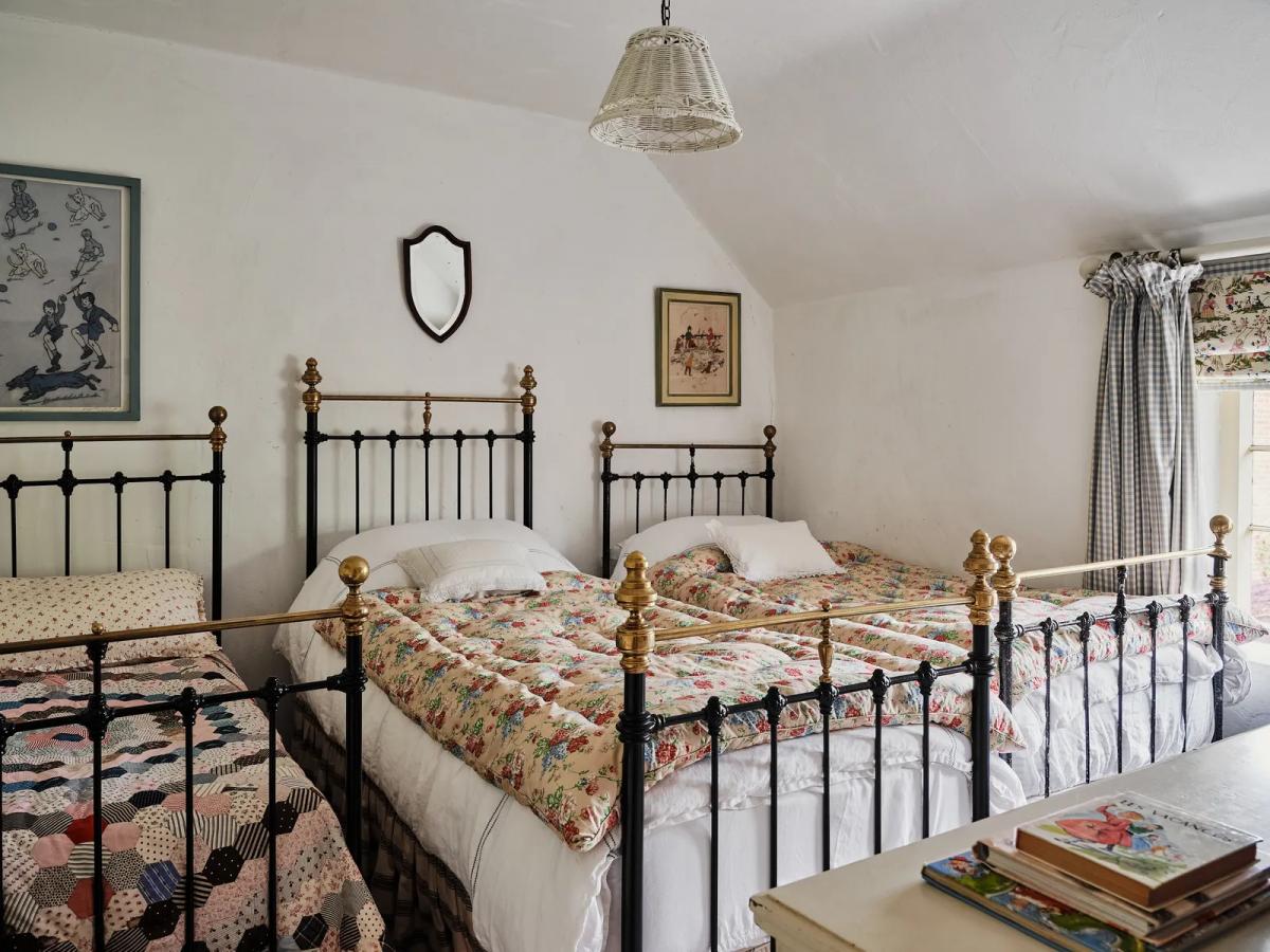 Спальня с железными одиночными кроватями и цветочными покрывалами