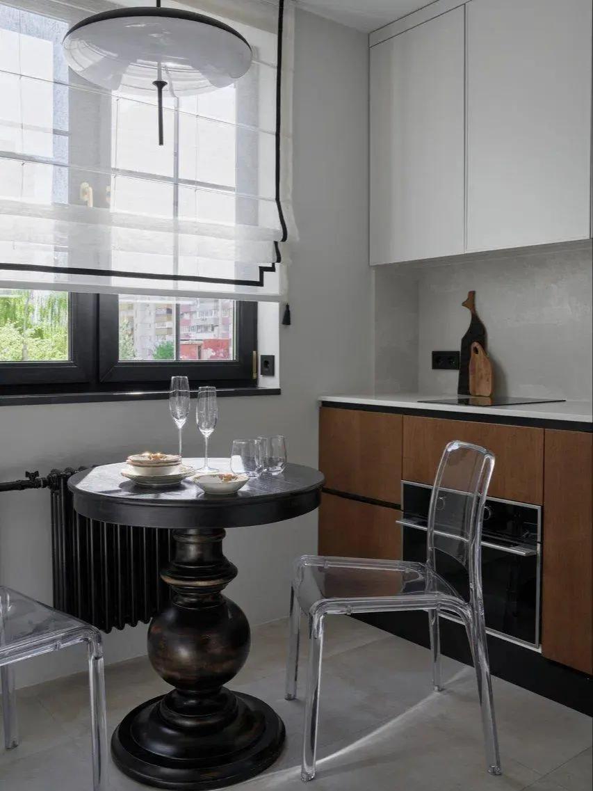 Круглый деревянный стол с массивной фигурной ножкой на кухне