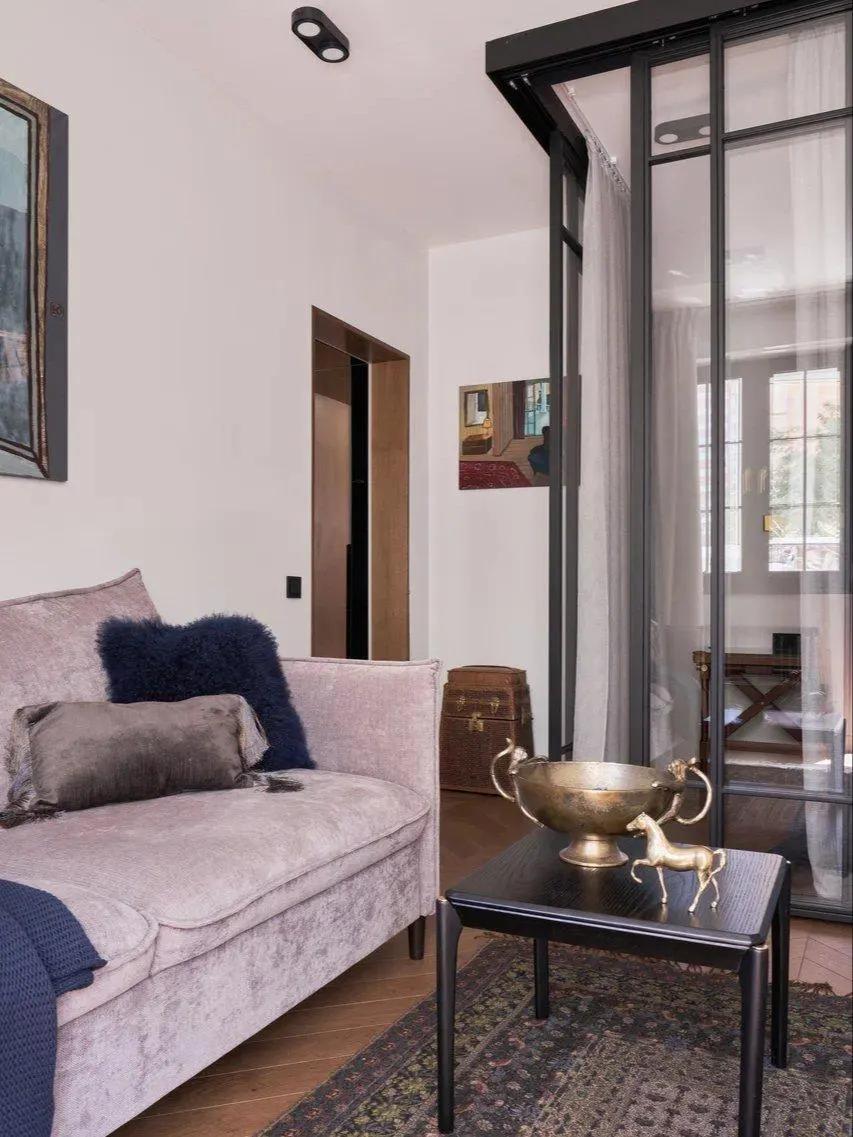 Спальное место в гостиной, отгороженное стеклянной перегородкой и шторой