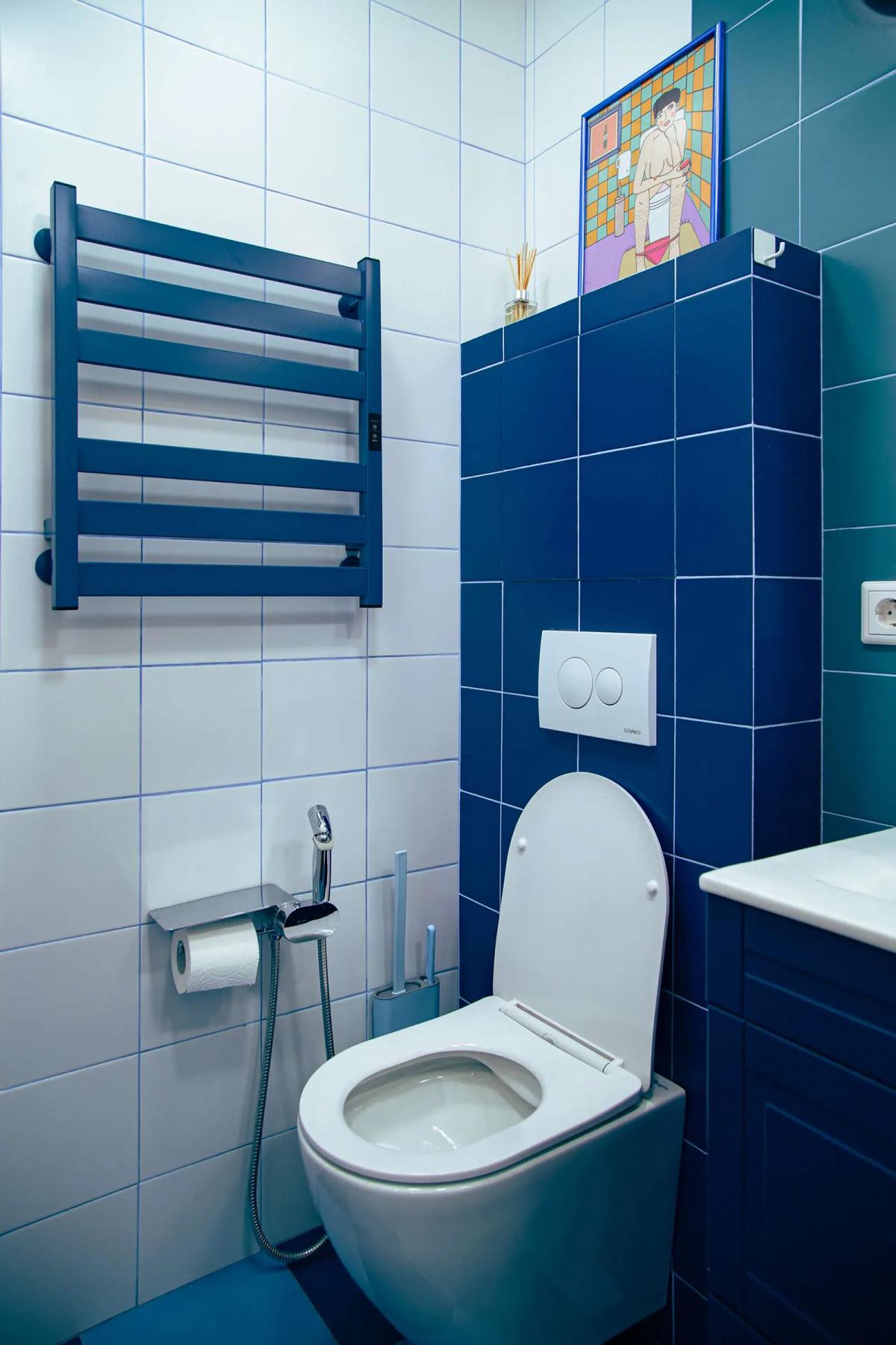 Синий полотенцесушитель и плитка в ванной комнате