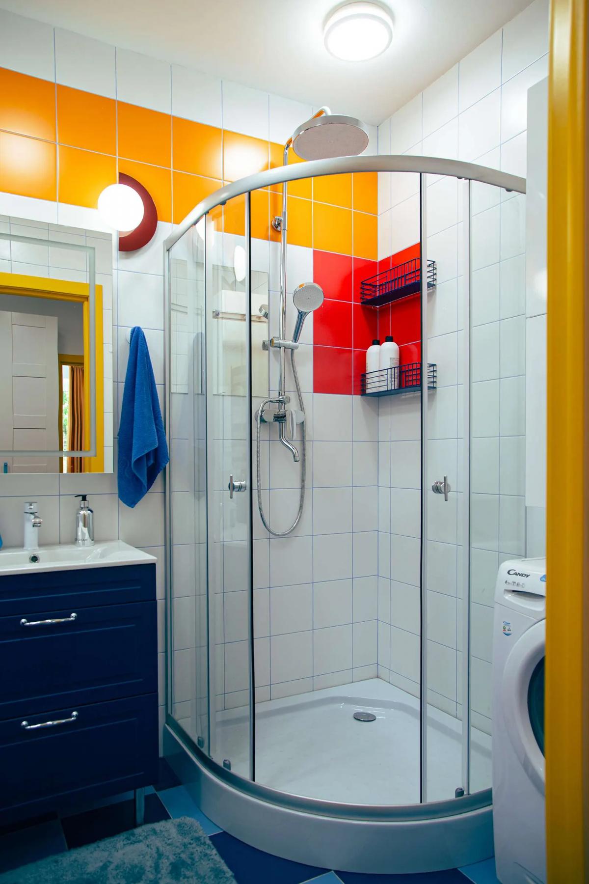 Душевая кабина в ванной, синяя тумба под умывальником.