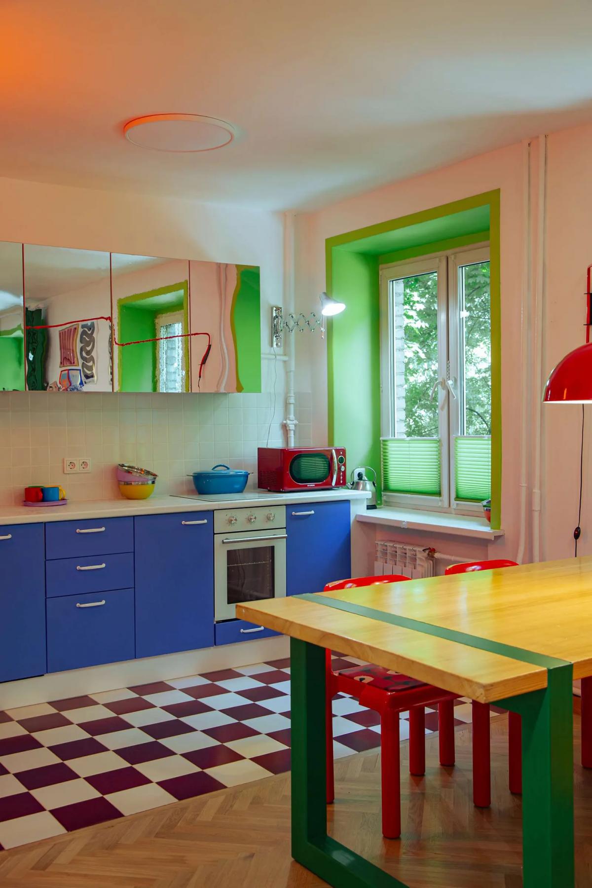 Яркая кухня в хрущевке, с зелеными окнами и синим кухонным гарнитуром