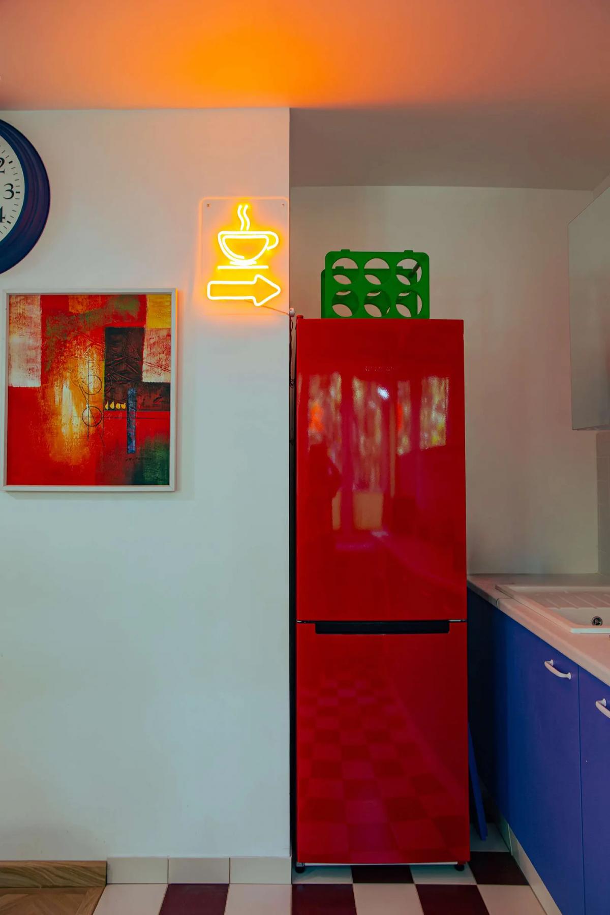 Красный холодильник на кухне, абстрактная картина и неоновая вывеска