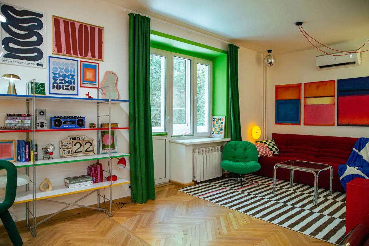 Гостиная со стеллажом и зелеными откосами у окон